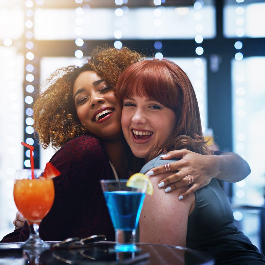 friends, hugging, drinks in hand